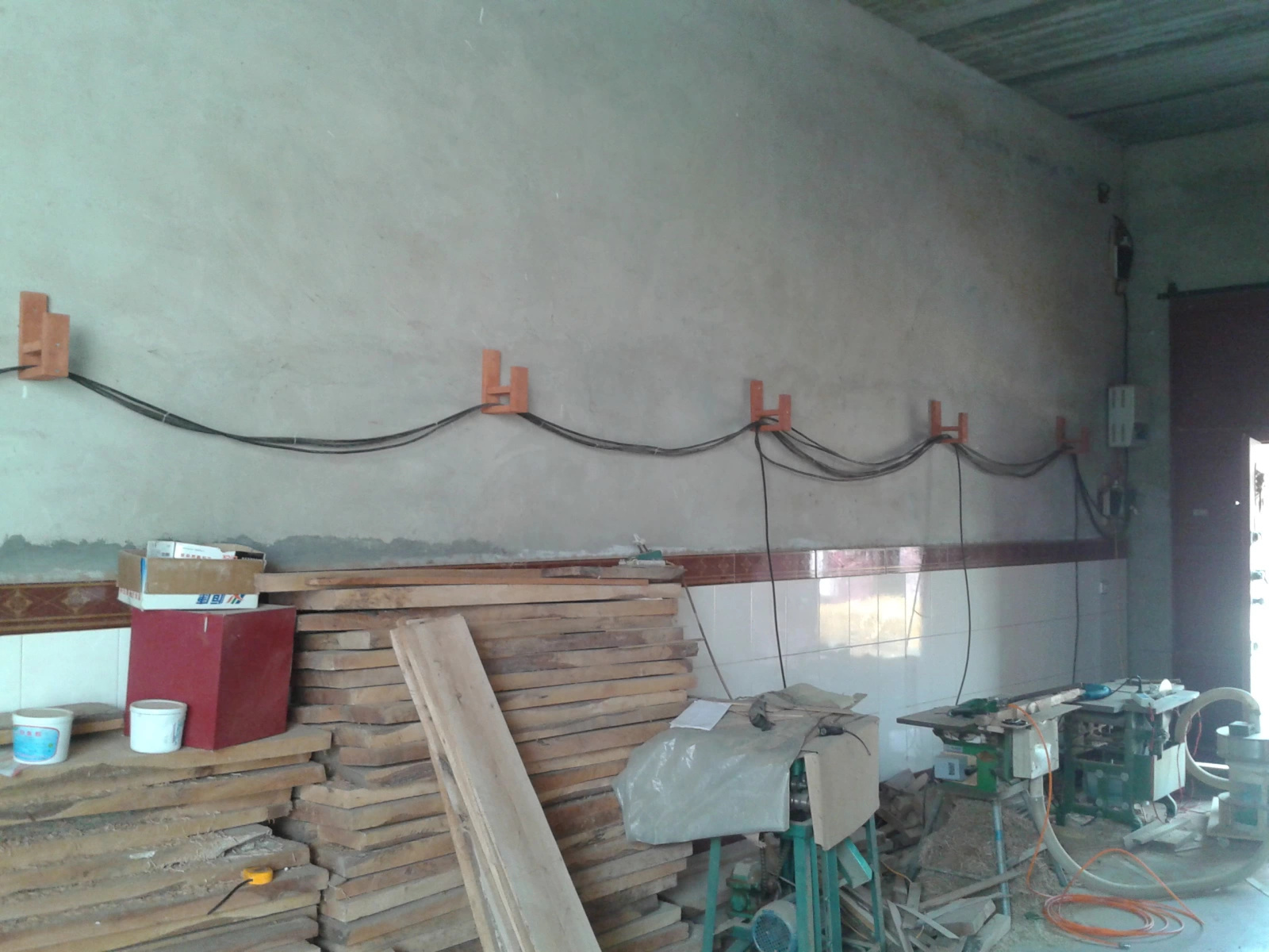 Workshop wall with handmade wooden brackets supporting cables